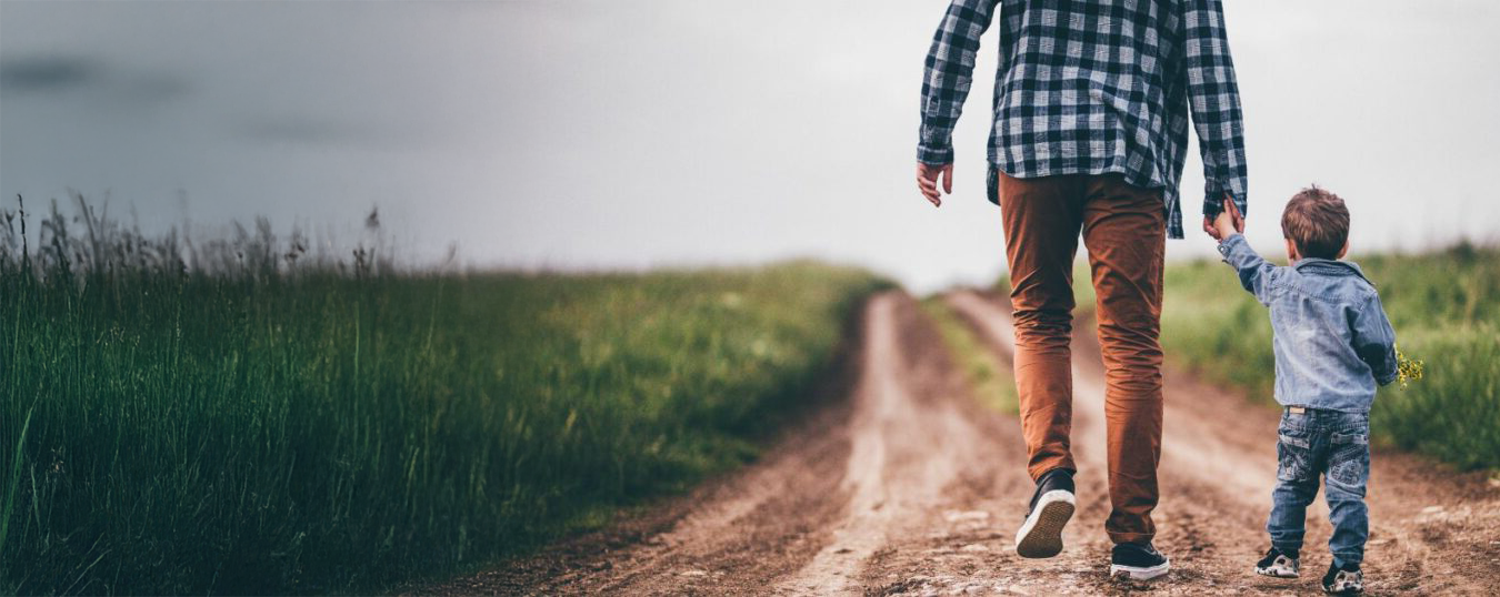 A father walking beside his young son